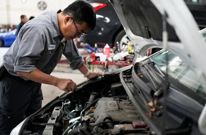 Auto mechanic Willie Chung works on a vehicle at the Express Auto Service Inc., in Chicago, Thursday, Sept. 19, 2024