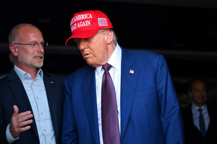 Donald Trump speaks with Brendan Carr, left.