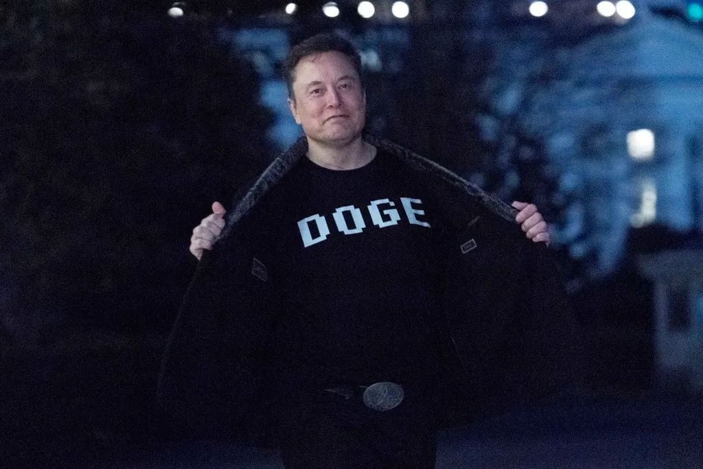Elon Musk flashes his T-shirt that reads "DOGE."