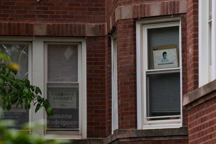 Signs are seen in the window of a building at an address listed in public records as the home of Elias Rodriguez, who police identified as the suspect in the killing of two staff members of the Israeli Embassy in Washington, Thursday, May 22, 2025, in Chicago.
