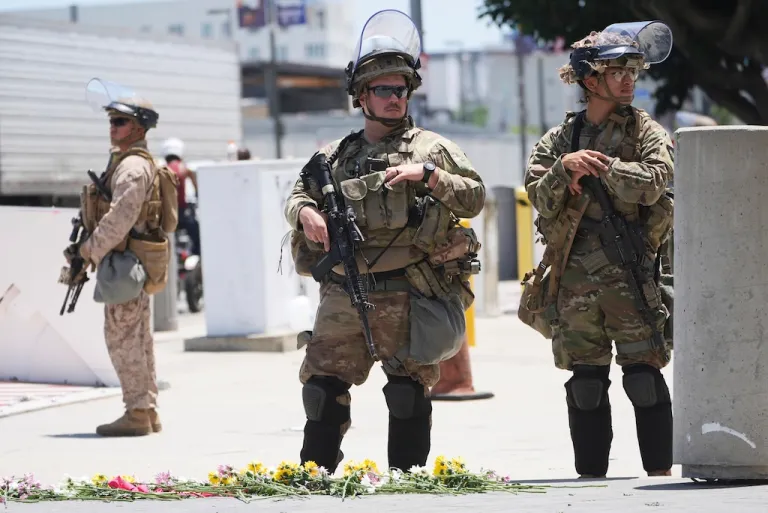 Members of the California National Guard and U.S. Marines guard a federal building.