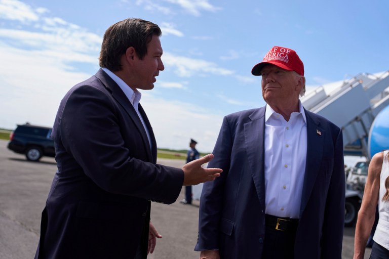 President Donald Trump listens as Gov. Ron DeSantis, R-Fla., speaks with reporters after arriving at Dade-Collier Training and Transition Airport, Tuesday, July 1, 2025, in Ochopee, Fla.