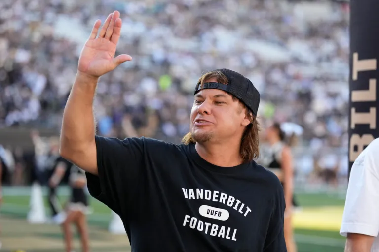 Theo Von waves in front of a crowd.