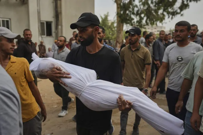 A relative carries the body of Palestinian child Muath Al-Basus, who was killed in an Israeli military strike, during his funeral outside Shifa Hospital in Gaza City, Thursday, Sept. 4, 2025.