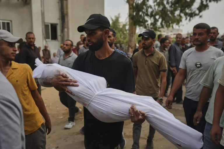 A relative carries the body of Palestinian child Muath Al-Basus, who was killed in an Israeli military strike, during his funeral outside Shifa Hospital in Gaza City, Thursday, Sept. 4, 2025.