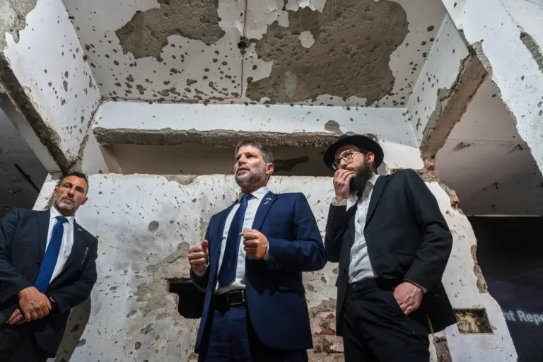 Israeli Finance Minister Bezalel Smotrich, center, and Director of Chabad House, Rabbi Israel Kozlovsky, right, look at a wall riddled with bullet marks from the 2008 terror attack at the Chabad Center in Mumbai, India, Tuesday, Sept. 9, 2025.