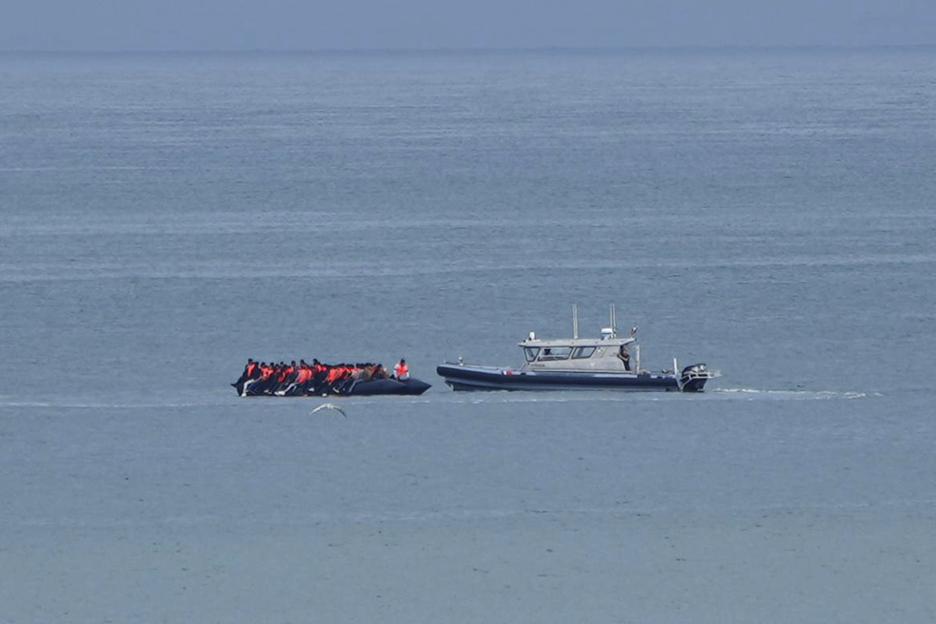 A boat thought to be carrying migrants is escorted by a vessel from the French Gendarmerie Nationale in the English Channel.