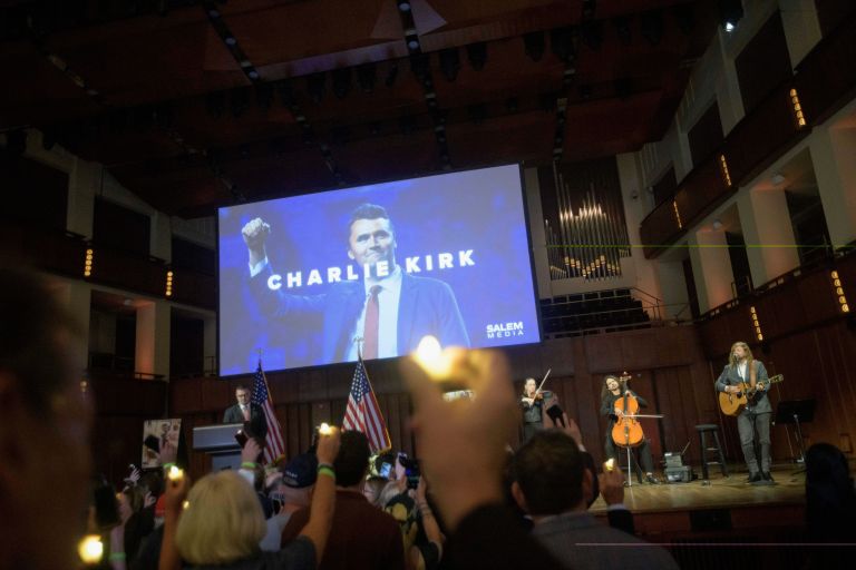 People hold candles and sing during a memorial and prayer vigil for Charlie Kirk at the John F. Kennedy Memorial Center for the Performing Arts, Sunday, Sept. 14, 2025, in Washington.
