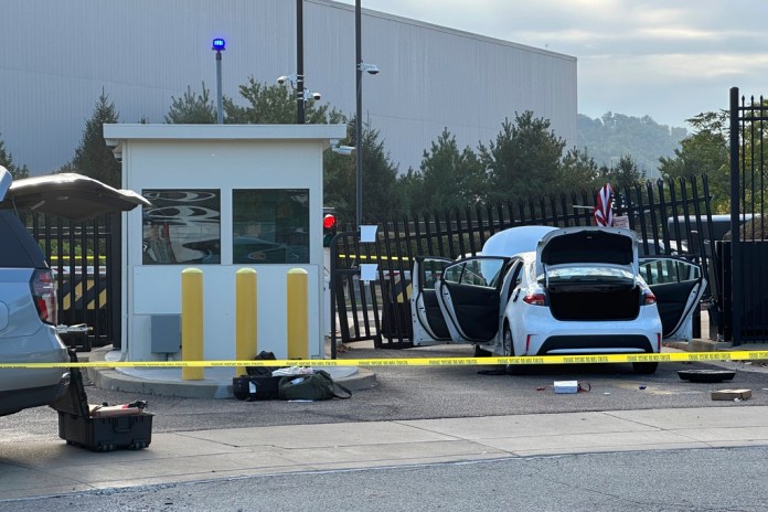 FBI officials inspect a car that rammed into the gate of the FBI building in Pittsburgh.