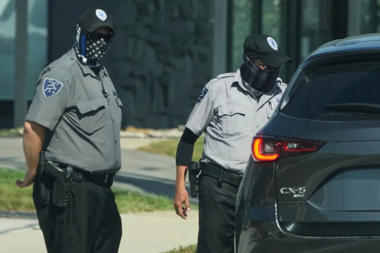 Federal agents (inside of a car) and security guards talk to each other outside of an ICE (U.S. Immigration and Customs Enforcement) processing facility in the Chicago suburb of Broadview, Ill., Wednesday, Sept. 17, 2025.