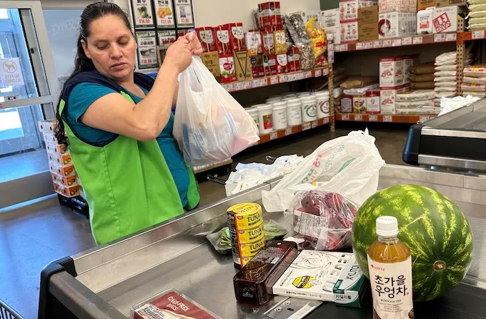 An employee works at a cash register in a grocery store in Schaumburg, Ill., Thursday, Sept. 18, 2025.