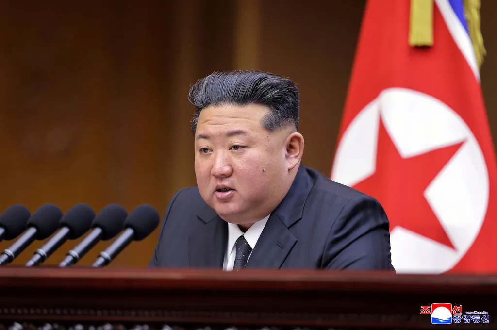 North Korean leader Kim Jong Un speaks into microphones.