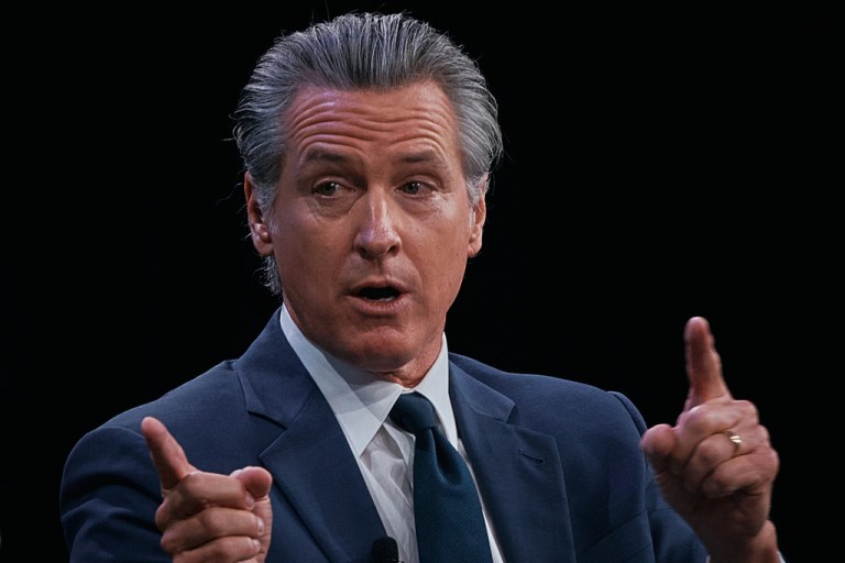Gavin Newsom, seated across from Bill Clinton, speaks at the Clinton Global Initiative's annual meeting in New York City.