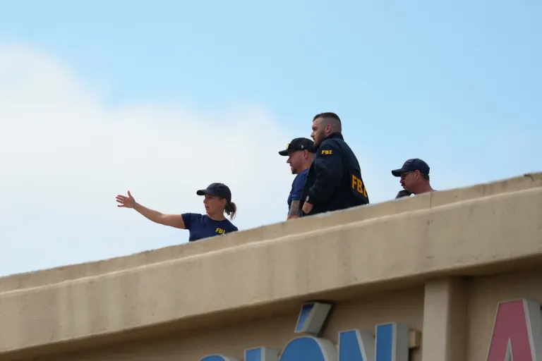 FBI agents scope out the scene of the Dallas ICE shooting from a rooftop.