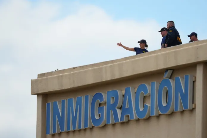 Law enforcement agents look around the roof of a building near the scene of a shooting at a U.S. Immigration and Customs Enforcement office in Dallas on Wednesday, Sept. 24, 2025. 