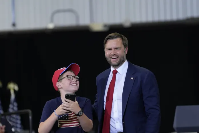 A young boy named Henry looks at Vice President JD Vance after taking a selfie with him.