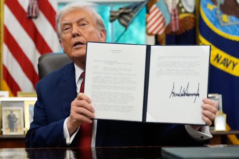 President Donald Trump holds a signed presidential memorandum.