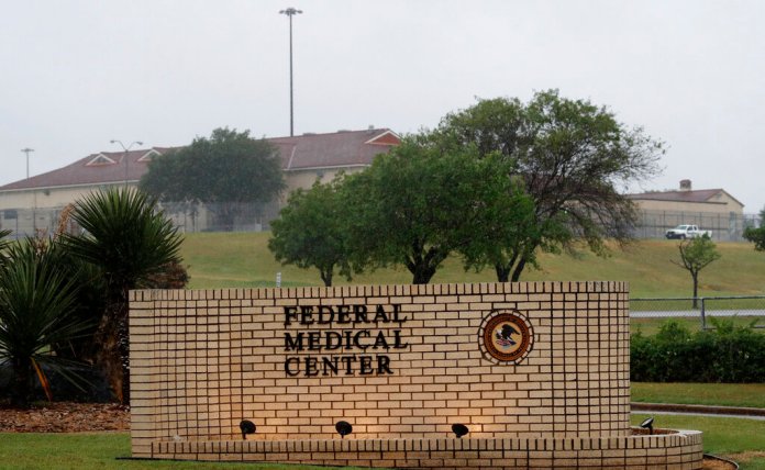 The front entrance of Federal Medical Center prison is lit up by lights in Fort Worth, Texas, Saturday, May 16, 2020. Hundreds of inmates inside the facility have tested positive for COVID-19 and several inmates have died with numbers expected to rise. (AP Photo/LM Otero)
