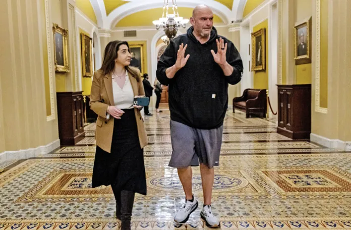 Sen. John Fetterman (D-PA) speaks to a reporter in a Senate corridor, Feb. 6, 2025. (Anna Rose Layden/Getty)