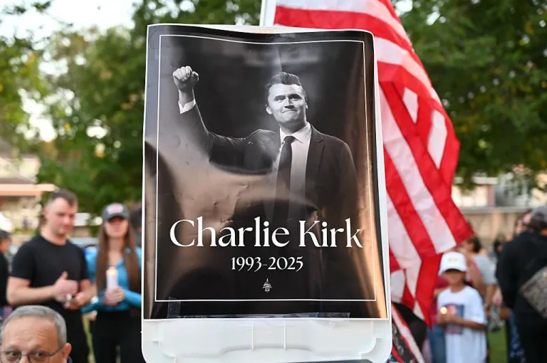Residents of Lemont, Illinois, come together in a serene park setting to pay tribute to Charlie Kirk during a vigil on September 11, 2025.Turning Point USA headquarters was established in Lemont in 2012 by founder Charlie Kirk. (Photo by Jacek Boczarski/Anadolu via Getty Images)