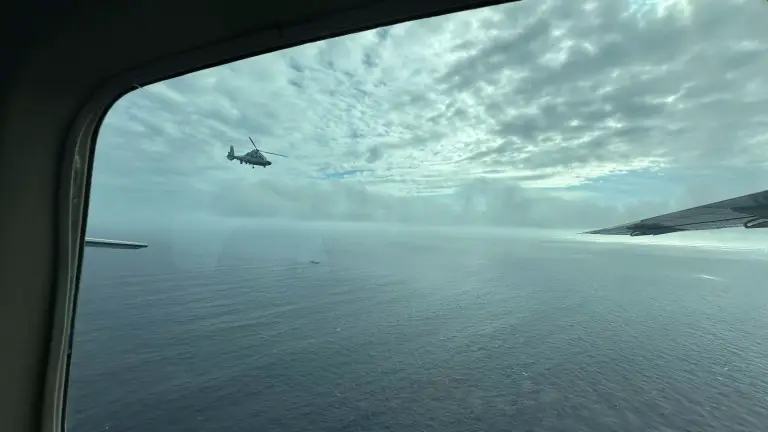 A Chinese military helicopter flies close to a Philippine Bureau of Fisheries and Aquatic aircraft above Scarborough shoal.