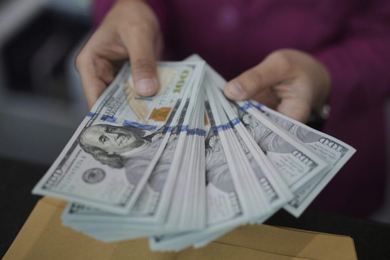 An employee shows U.S dollars banknotes.