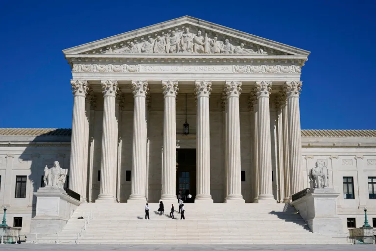 Officials stand on the Supreme Court steps.