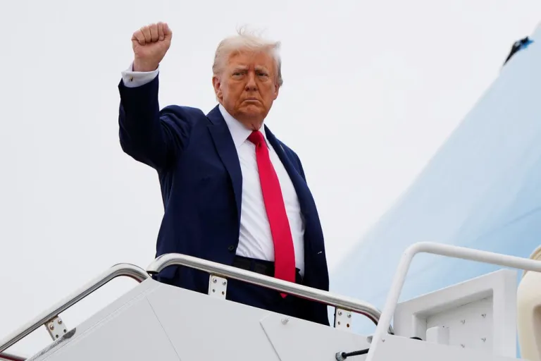 President Donald Trump raises his fist as he boards Air Force One.