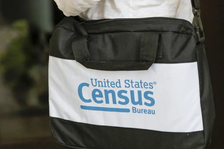 A briefcase of a census taker is seen as she knocks on the door of a residence.