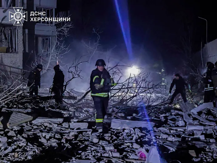 In this photo provided by the Ukrainian Emergency Services on Thursday, Feb. 20, 2025, rescuers clear the rubble from a multi-story building which was heavily damaged by a Russian strike on a residential neighbourhood in Kherson, Ukraine.
