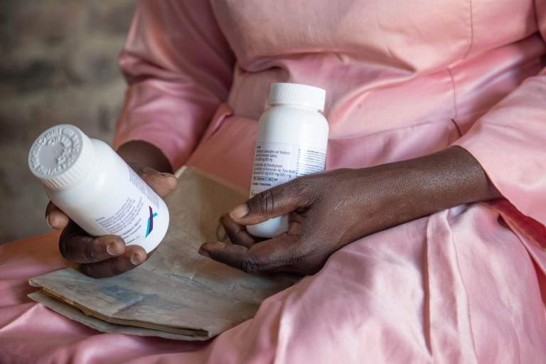 FILE - Florence Makumene holds HIV medication that she received through funding from the U.S. President's Emergency Plan for AIDS Relief (PEPFAR), along with her hospital records book, at her home in Harare, Zimbabwe, Feb. 7, 2025.