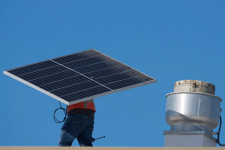 A worker carries a solar panel on the roof of the Alta Sea building, an urban, ocean-based research and blue technology innovation campus, at Berth 58 in the Port of Los Angeles on Sept. 4, 2025. (AP Photo/Damian Dovarganes)