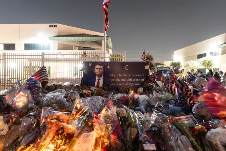 Flowers, candles, and balloons fill a makeshift memorial for Charlie Kirk.