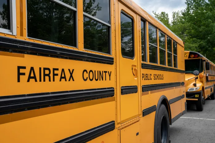 Fairfax County Public School buses idle at a middle school in Falls Church, Va., July 20, 2020. (AP Photo/J. Scott Applewhite, File)