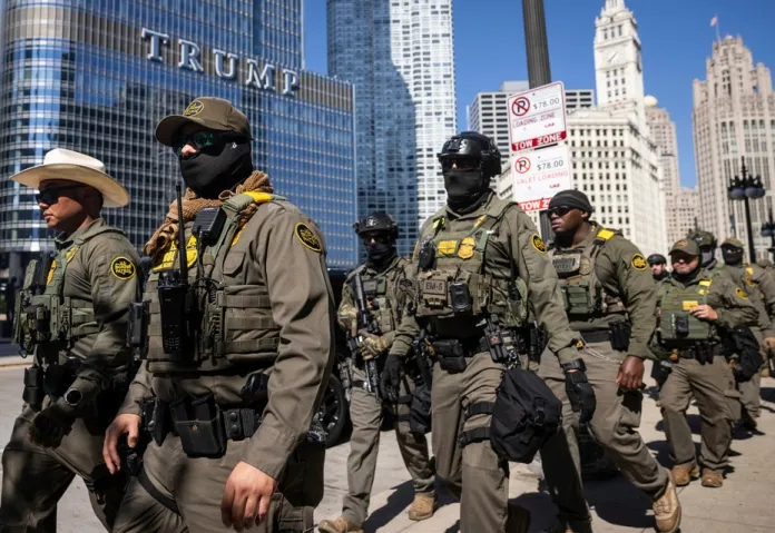Federal agents from U.S. Immigration and Customs Enforcement and U.S. Customs and Border Protection walk along West Wacker Drive in the Loop, Sunday, Sept. 28, 2025, in Chicago. (Ashlee Rezin/Chicago Sun-Times via AP)