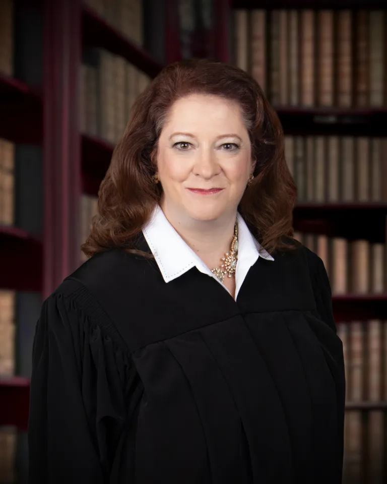 Wisconsin Appeals Court Judge Maria Lazar poses in front of shelves of books.