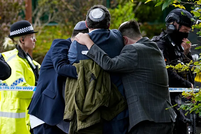 Members of the Jewish community comfort each other near to the Heaton Park Hebrew Congregation synagogue, in Crumpsall, Manchester, England, Thursday, Oct. 2, 2025 after Police reported that two people were killed and three others were seriously injured in a synagogue attack in northern England. 