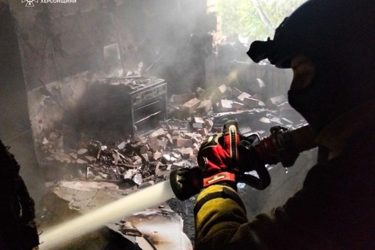 In this photo provided by the Ukrainian Emergency Service on Friday, Oct. 3, 2025, a rescuer puts out a fire of a residential house damaged by a Russian strike on Kherson, Ukraine.