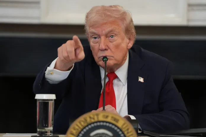 President Donald Trump points to a reporter at a White House roundtable.
