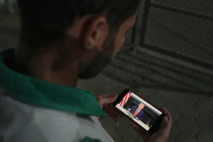 UN cheers Trumps Gaza plan from the sidelines, seeks to insert itself into regions future 3 Palestinian paramedic Saeed Awad looks at his phone displaying an image of U.S. President Donald Trump, following the announcement that Israel and Hamas have agreed to the first phase of a peace plan to pause fighting, as he stands at Al-Aqsa Hospital, in Deir al-Balah, in the central Gaza Strip, Thursday, Oct. 9, 2025. (AP Photo/Abdel Kareem Hana)