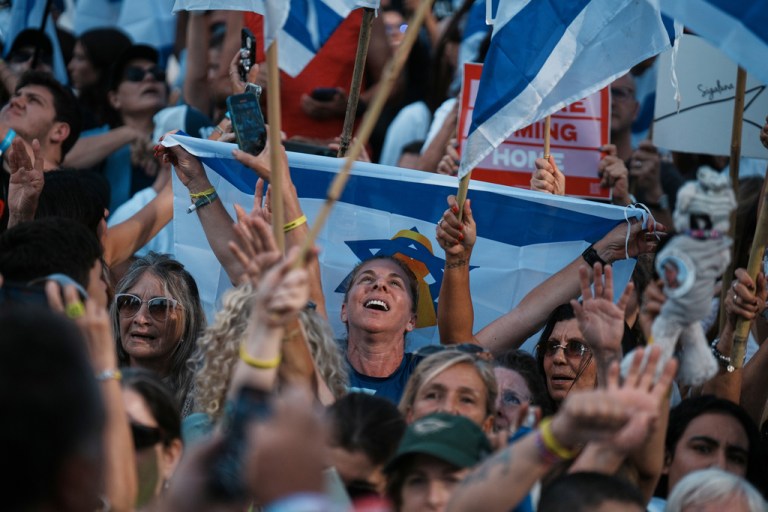 People react as they gather to watch a live broadcast of Israeli hostages released from Gaza.