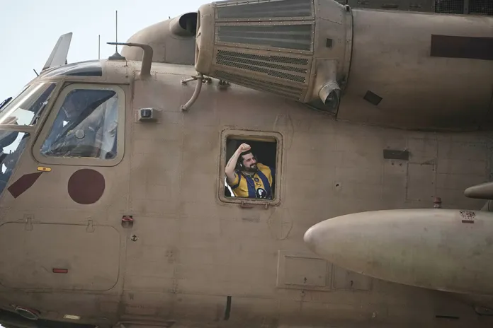 Ziv Berman, an Israeli hostage released from the Gaza Strip gestures from the window of a helicopter landing at the Sheba Medical Center in Ramat Gan, Israel, Monday, Oct. 13, 2025. (AP Photo/Leo Correa)