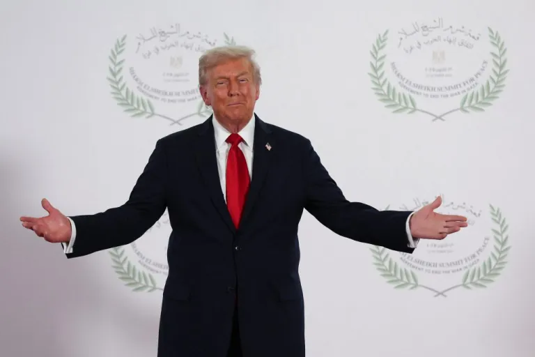 President Donald Trump waits to greet leaders during a summit.