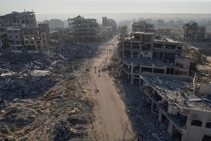 Palestinians walking through rubble in Gaza City