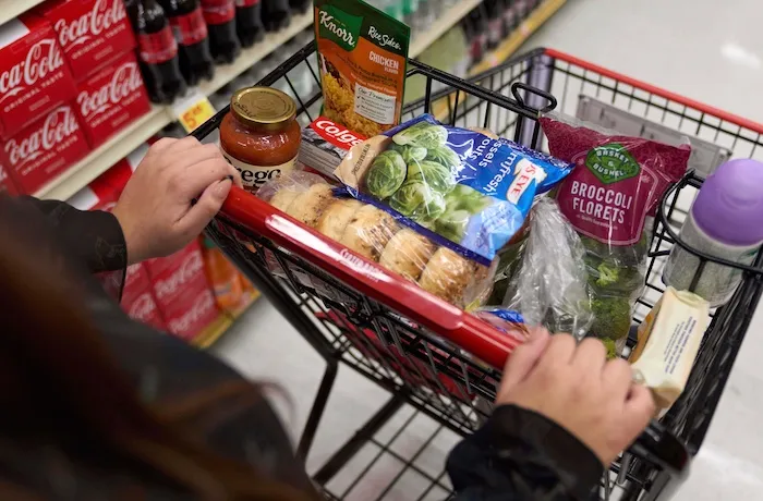 FILE - A California's SNAP benefits shopper pushes a cart through a supermarket in Bellflower, Calif., Feb. 13, 2023.