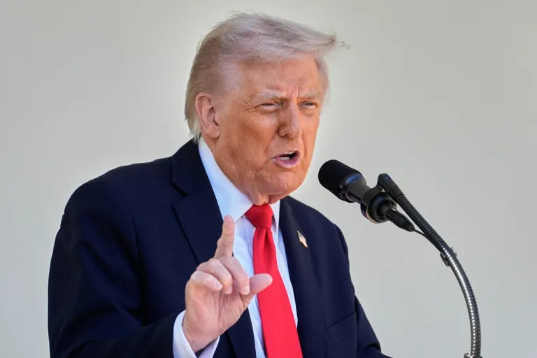 President Donald Trump speaks into a microphone.