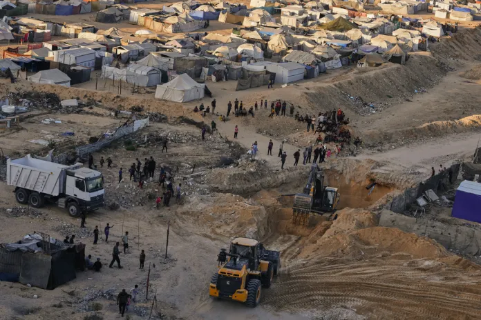Palestinians watch machinery and some workers from Egypt searching for the bodies of hostages.