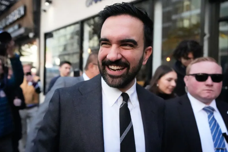 Zohran Mamdani tries to talk to pedestrians while surrounded by reporters in New York.
