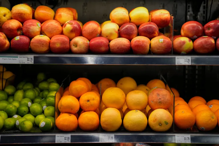 Produce is displayed on shelves in a market.