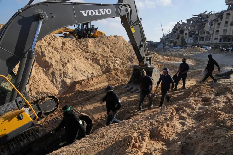 Members of the al-Qassam Brigades, the military wing of Hamas, and Egyptian workers search for the bodies of hostages in a tunnel.